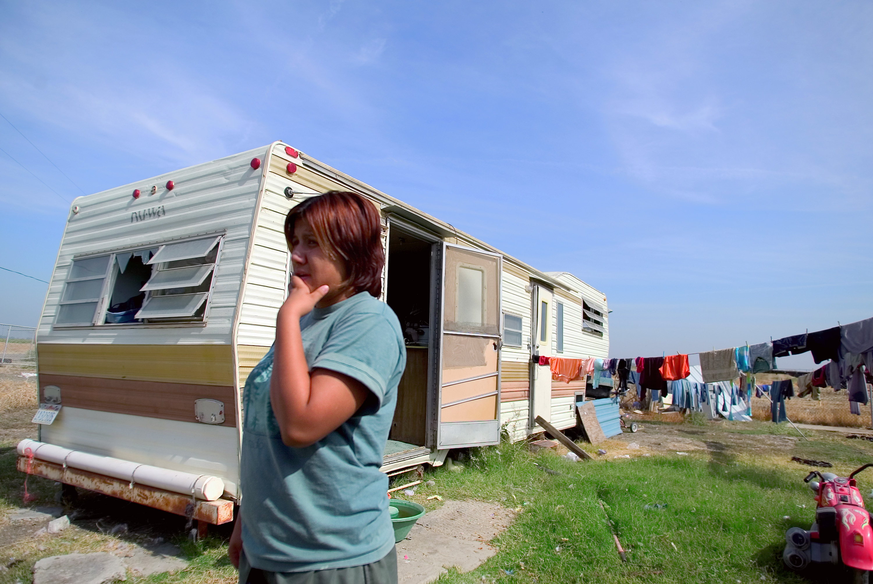 Woman standing outside her trailer near Firebaugh, California. 2007